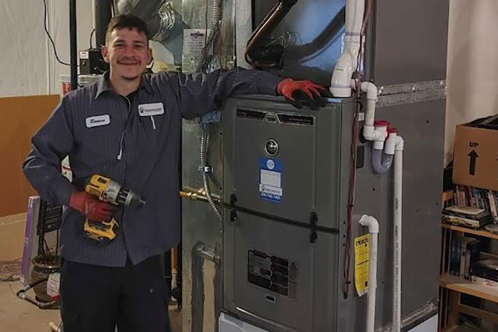 Technician standing by installed furnace